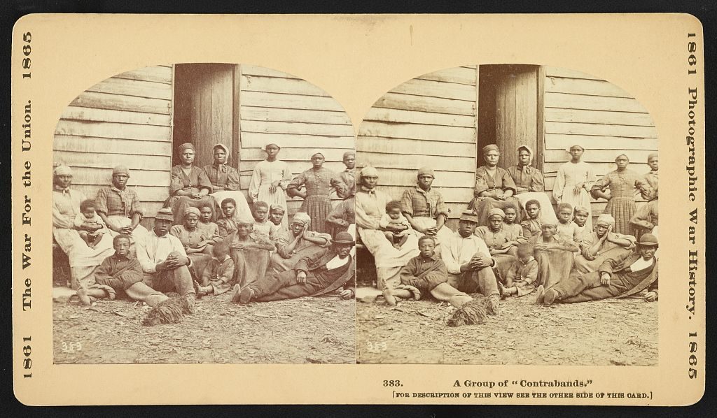 Stereograph showing a group of slaves including men, women and children gathered outside a building at the Foller Plantation in Cumberland Landing, Pamunkey Run, Virginia.